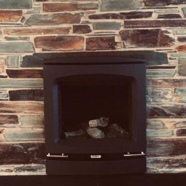 Installation of a Gazco Logic HE Inset Gas Fire with Logs featuring the Vogue Front